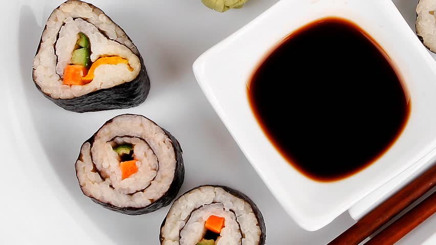 Maki Sushi : Maki Rolls and California rolls made of fresh raw Salmon(sake) Tuna(maguro) and Eel(unagi) . on white dish with sticks hidef slow motion intro