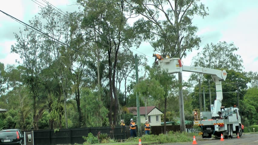 Queensland- Australia circa 2013  Recent floods and wild weather have caused damage and death. Worker clears trees from power lines.