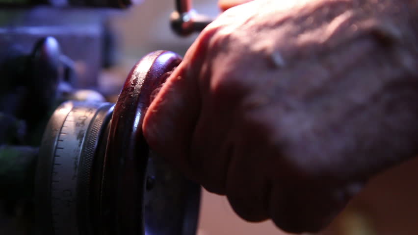 worker handles metal piece on the lathe 5