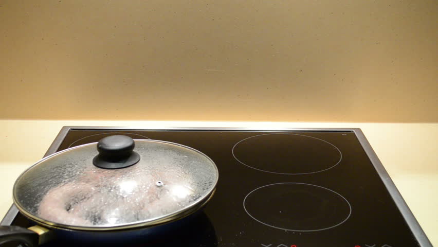 fresh meat sausages baking. hand open top of pan and hot vapour evaporate.