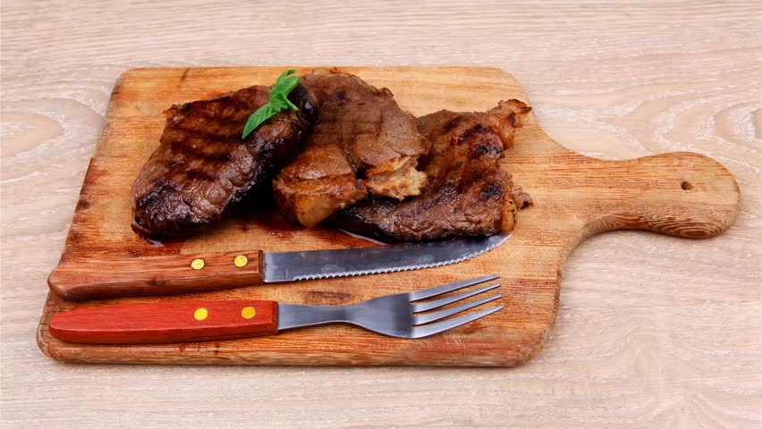 bbq beef meat fillet on wooden plate with cutlery