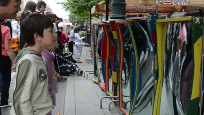 VILNIUS, LITHUANIA - SEPTEMBER 1: People kids look at distort fun freak mirror change body form on September 1, 2012 in Vilnius.