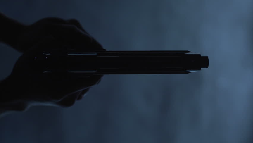 Man with 9 mm handgun takes a shot. Shot from above