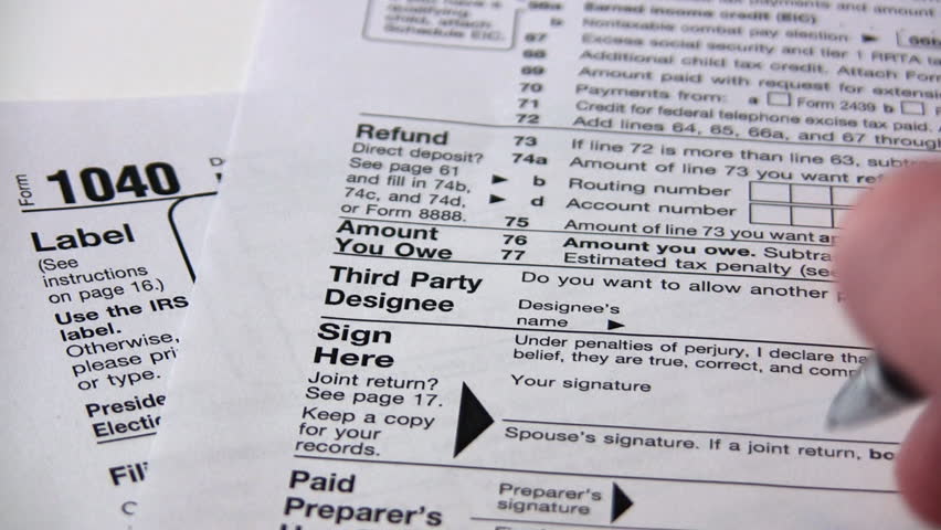 Signing a 1040 income tax return form.
