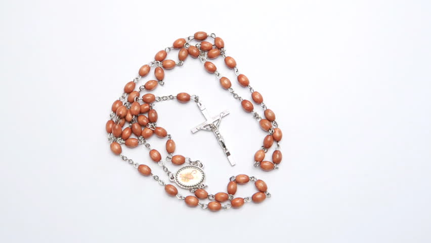 Rosary beads on white surface revolving video
