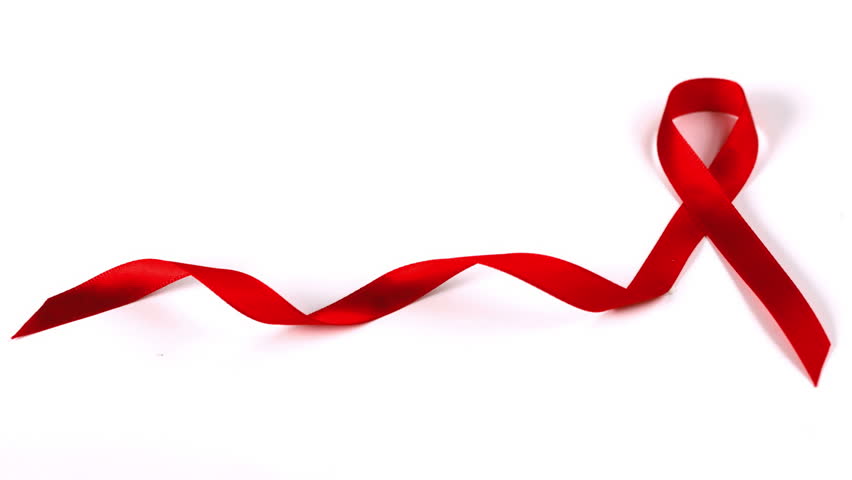 Condom dropping down beside Aids red ribbon symbol in slow motion