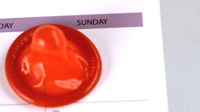 Condom falling on a calendar in slow motion