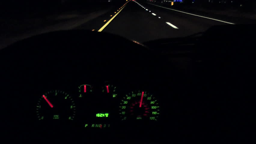 Driver POV, Dashboard, illuminated at night, reveals speed limit, fuel gage, rpm, ticks off mileage as car travels on open highway. 1080p