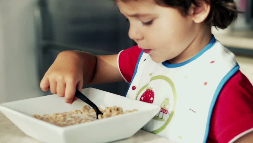Little boy eating cornflakes with milk, slow motion shot at 240fps
