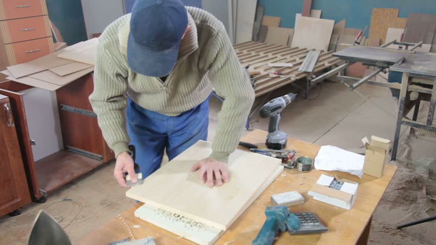 Furniture maker at work in workshop, manufactures kitchen furniture
