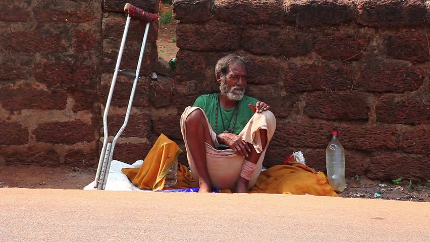 CALANGUTE, INDIA - MARCH 11, 2013: Homeless man sitting on the ground and waiting for alms from passers-by. on March 11, 2013 in Calangute, India
