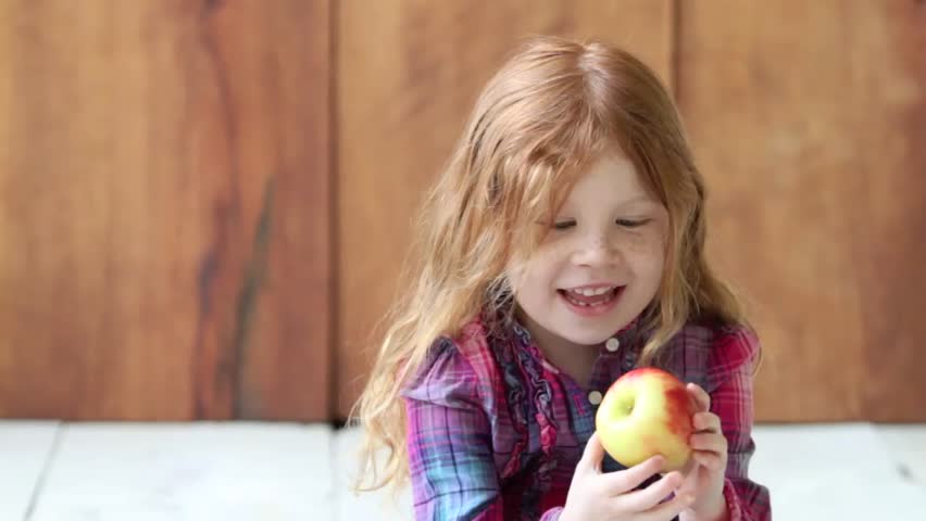 Little girl eating an apple