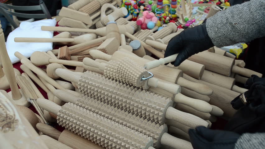 Various handmade wooden kitchen utensil tools pin rolling-pins and hand with glove choose it in city market fair