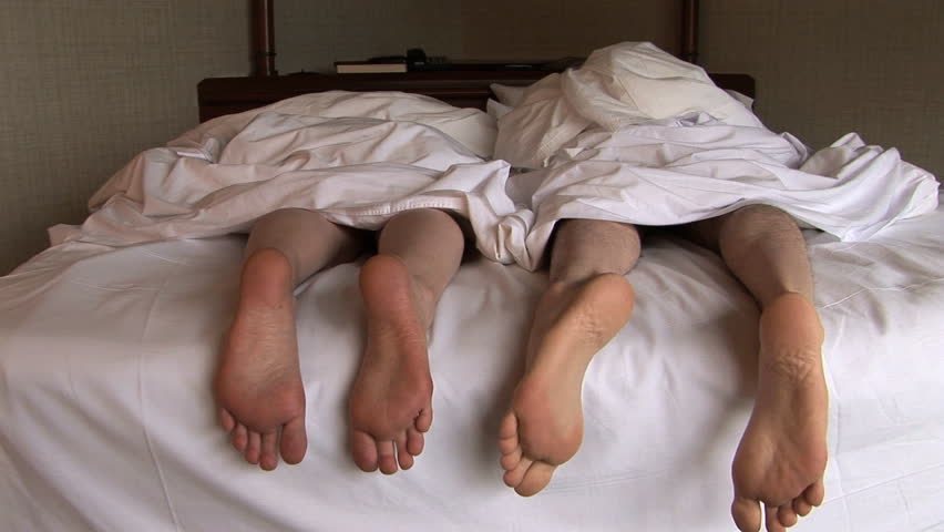 Couple in bed playing footsie, Seattle, Washington