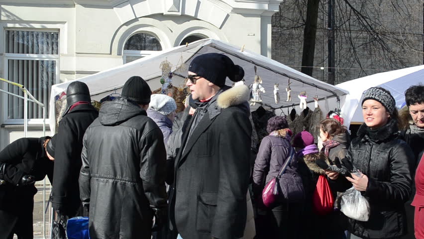 VILNIUS, LITHUANIA - MARCH 02: people mob straw embellishments stall sunny day street fair on Mrch 02, 2013 in Vilnius.