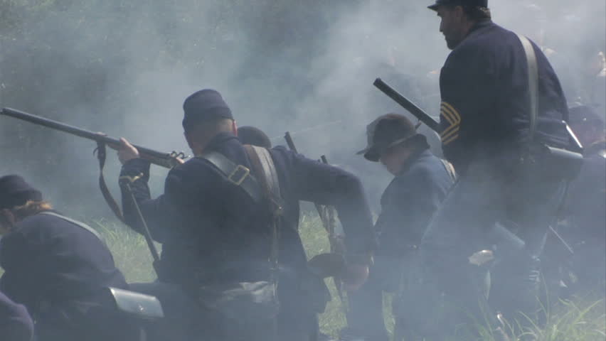 GEORGIA - OCTOBER 2008 - large-scale, epic Civil War anniversary reenactment -- in the middle of battle.  Union dismounted Cavalry on the smoky firing line as cannon fires behind them.  Battle smoke.