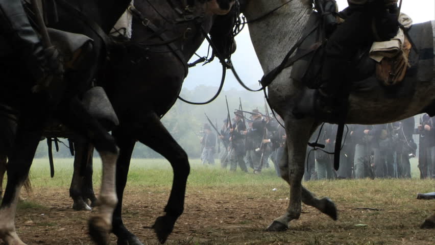 GEORGIA - OCTOBER 2008 - large-scale, epic Civil War anniversary reenactment -- in the middle of battle.  Confederate Cavalry in battle engage Union Infantry on the edge of a woods.  Combat smoke.