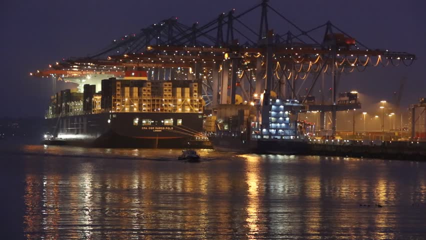 Hamburg,Germany - December 12, 2012, Container ship at the Burchardkai - a terminal at the harbour in Hamburg. One little boat is driving on the river. Night shot. 