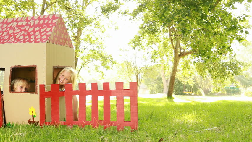 Video of happy little children sitting in playhouse. 