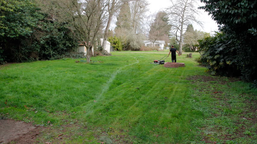 A man starts the huge job of mowing this giant backyard with a push mower in this creative time lapse shot at one frame every second and compiled together at 30 fps.