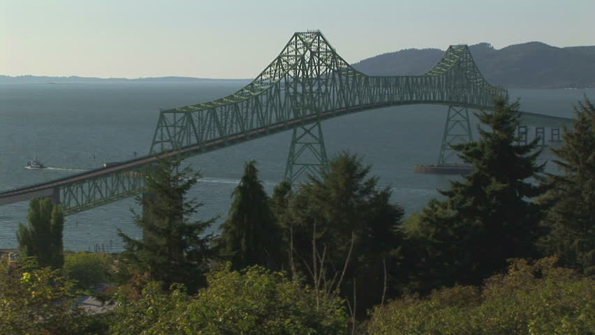 Overview of Astoria bridge with passing tugboat and barge, OR