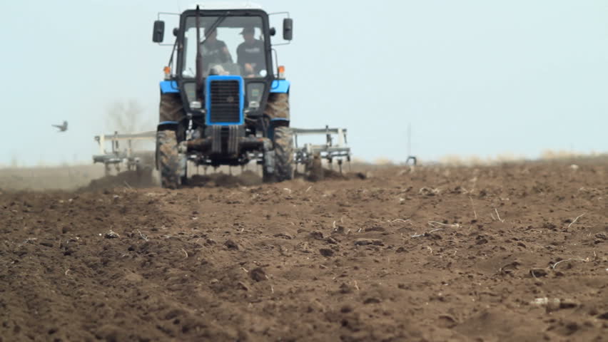 Tractor slowly moving on the field,ploughing farm land