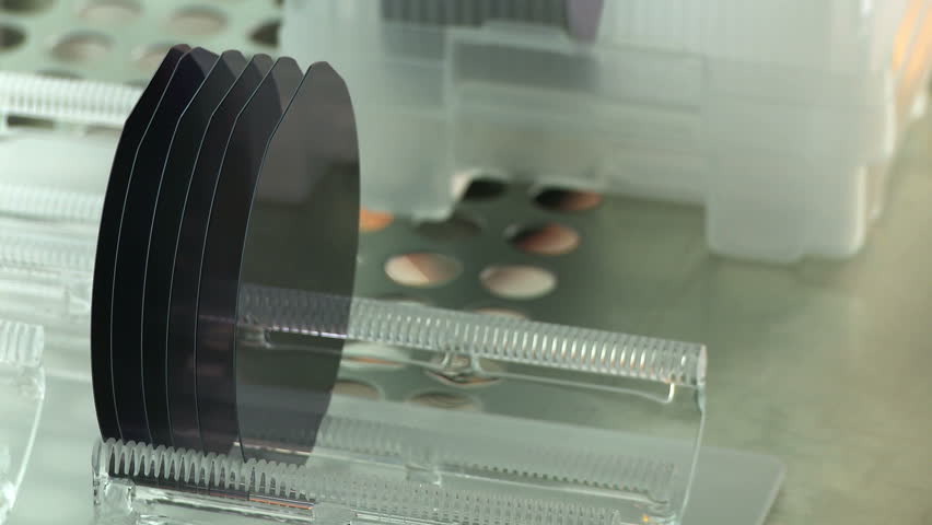 Detail view of silicon wafers being prepared to go into a kiln as part of a manufacturing process in a clean room.