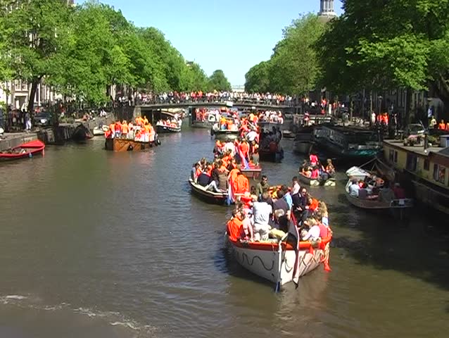 Dutch orange crowd celebrating queensday in Amsterdam canals in the Netherlands