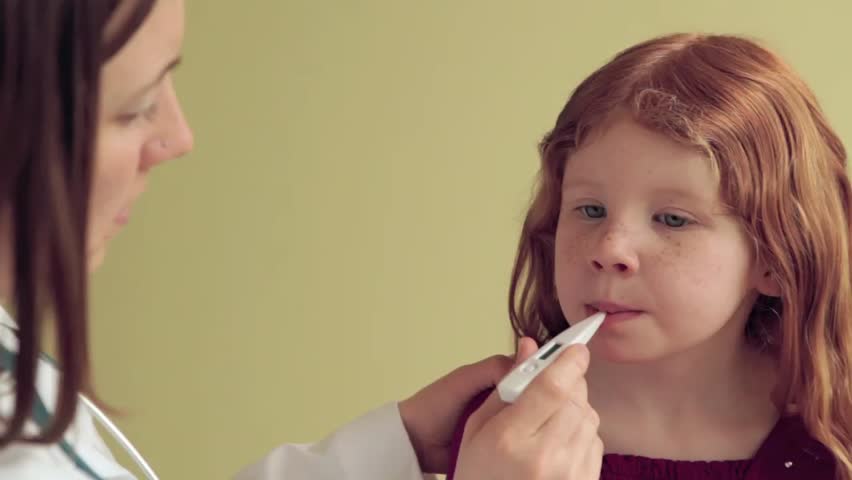 Female Pediatrician taking temperature of a female child.