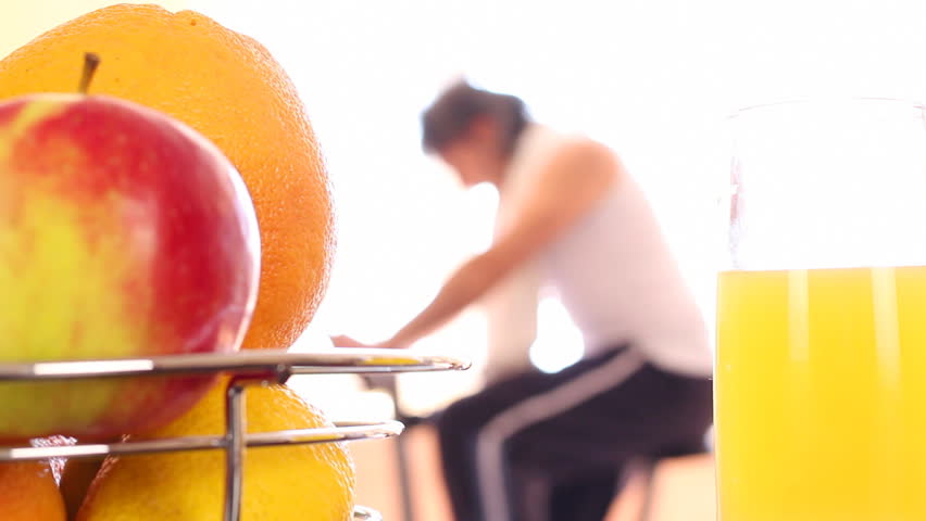 Healthy Life. A man (woman) rides a stationary bike, picks up a fresh juice