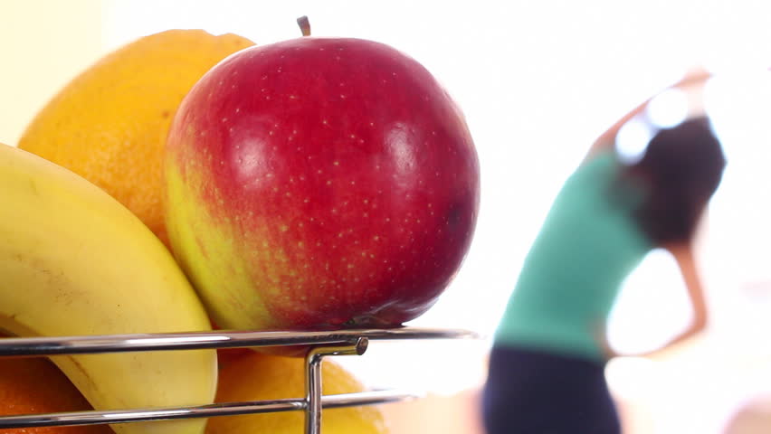 Healthy Life. A man (woman) rides a stationary bike, picks up an apple