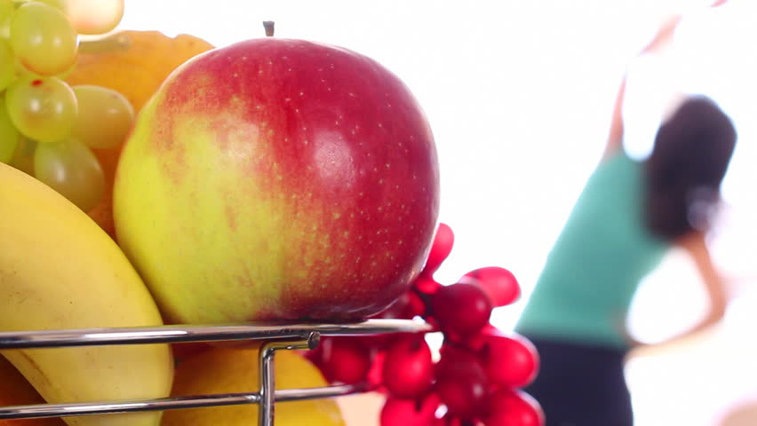 Healthy Life.A man (woman) rides a stationary bike, picks up an apple