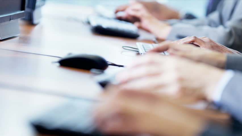 Multi ethnic IT team working in technical support center close up hands shot on RED EPIC