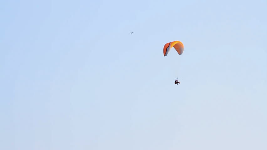 Paragliding over the mountains against clear blue sky