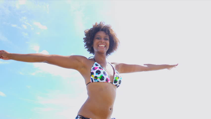 Beautiful African American female reveling in her lifestyle beside a tropical ocean shot on RED EPIC
