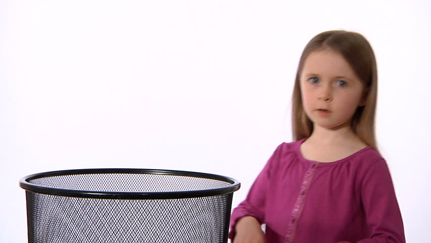 Little girl sneezing - she catches a cough and sneeze in a tissue and puts it into a bin