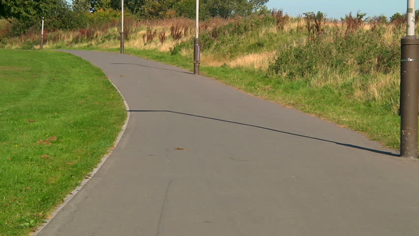 Little girl learning to ride her bicycle with help from her dad - dolly