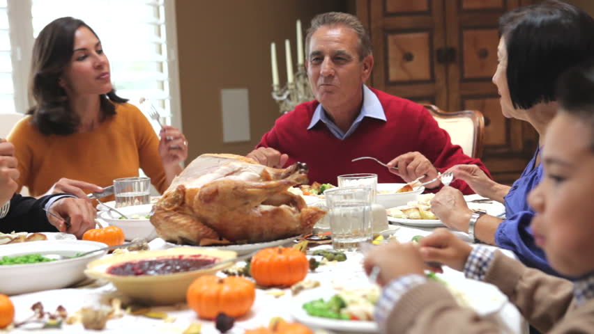 Camera tracks across table as extended family sit and enjoy thanksgiving dinner. Shot on Canon 5d Mk2 with a frame rate of 30fps