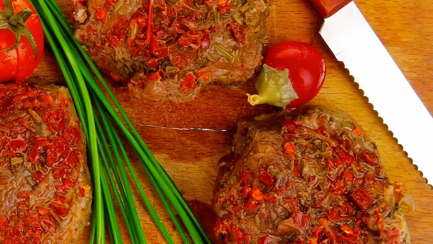 spicy meat on wood with pepper and chives