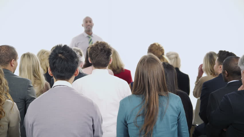 A diverse group of business people of mixed ages are listening to a presentation at a business seminar and asking questions. Isolated on white in a studio shot.
