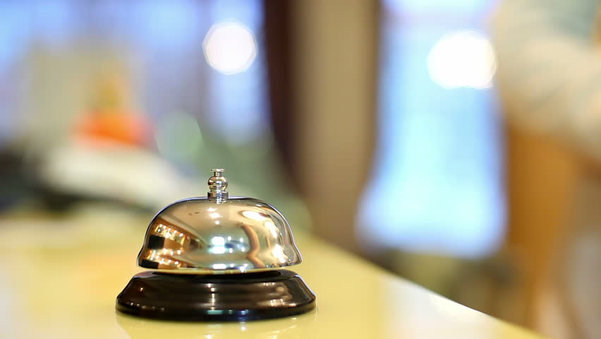 A female hand ringing silver service bell