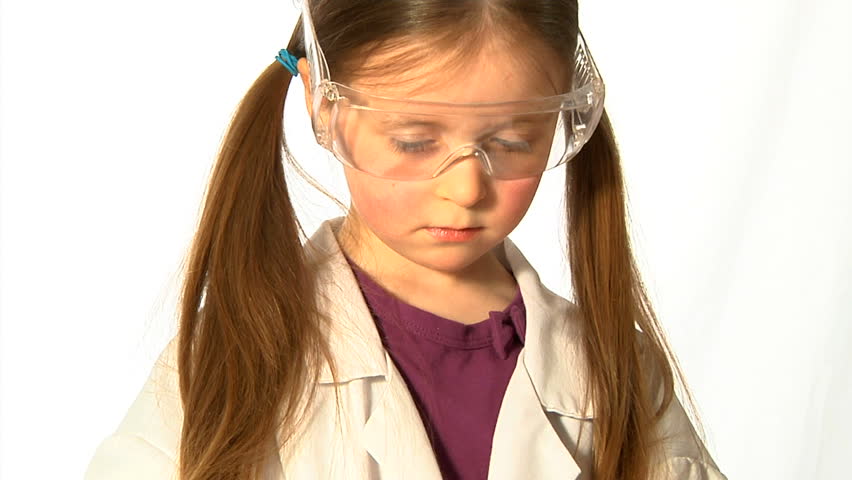 Young Scientist - A little girl, wearing adult safety glasses and lab coat, decants green liquid from a conical flask.