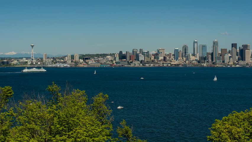 Elliot Bay and the Seattle waterfront with both commercial and recreational boats on the bay during a sunny spring day