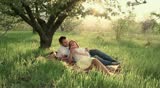 Couple eating an apple at sunset
