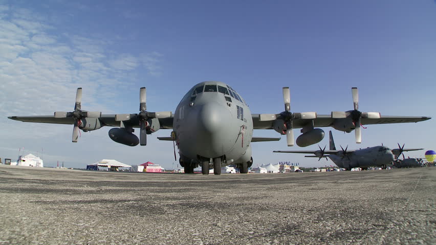 Lockheed Hercules military transport aircraft parked at an airshow.  Static camera.