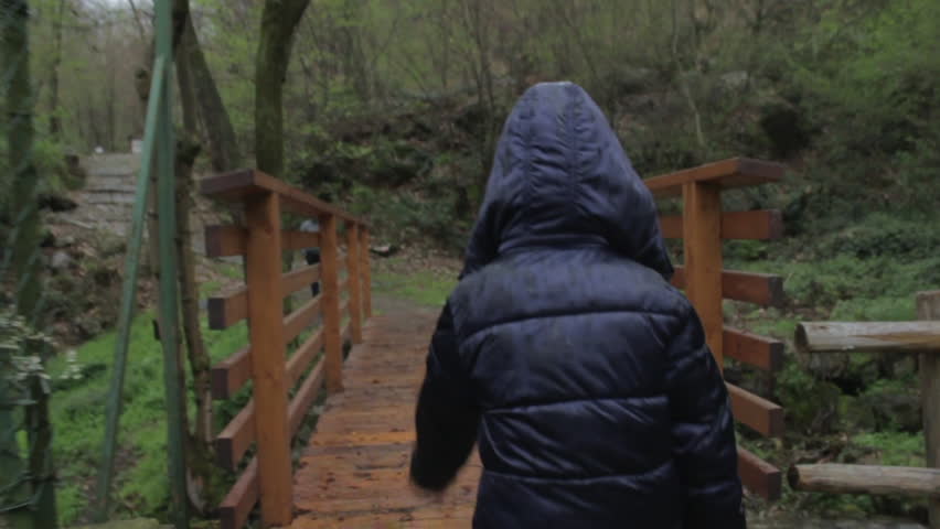 A little girl hooded, walking in the woods self-confident/Litte girl walking in the wood/ Shooting with Canon 600 D with a steady-cam. 