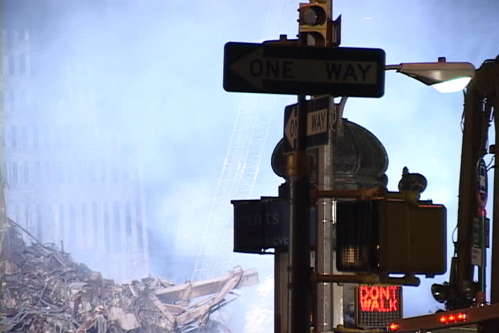 NEW YORK CITY - SEPTEMBER 28, 2001: One way traffic sign with smoky rubble and remains of World Trade Center in background.
