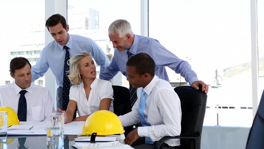 Group of architects looking at plans in the meeting room