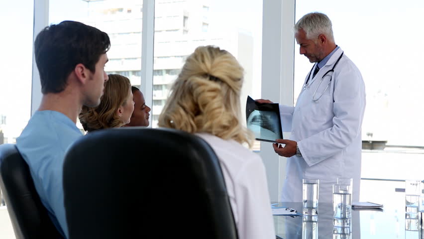 Medical team looking at x-ray in a conference room