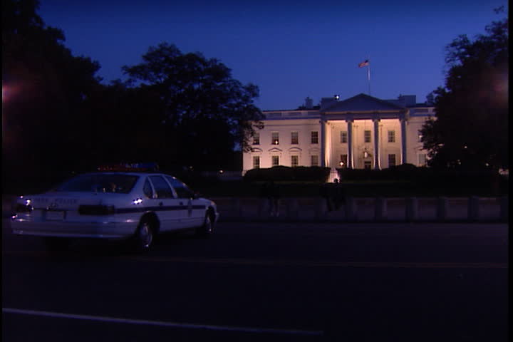 WASHINGTON, D.C. - OCTOBER 17, 2001: LS United States Park Police car parked in front of White House North Portico at dusk, camera pans left to follow postal service truck down Pennsylvania Avenue.